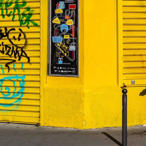 A woman wearing a hijab with a bouquet of flowers in her hand walks down a street in the Barbes district in Paris on June 25, 2023.